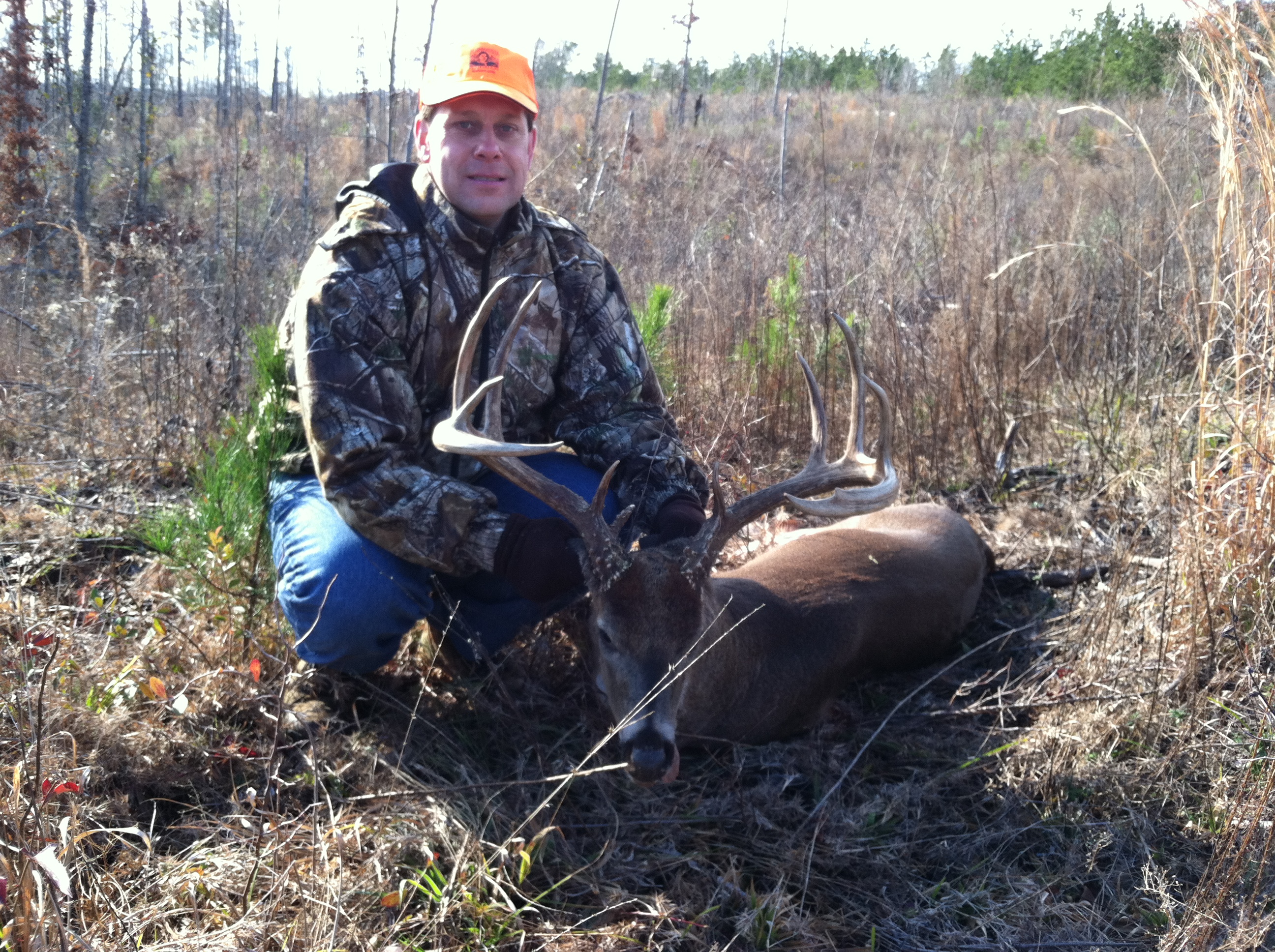 Hunter in blaze orange with a harvested Maine buck